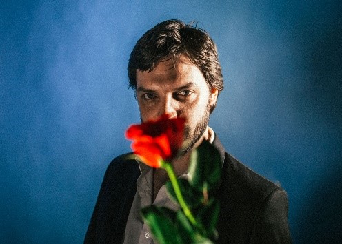 portrait of Tom Hogan holding a rose