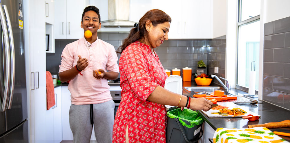 FOGO (easy english) man and woman in kitchen, using FOGO for food scraps